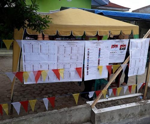 The staggeringly long list of candidates voters were choosing between hangs outside a polling station in North Sumatra. Photo from Wikimedia Commons/ Davidelit.