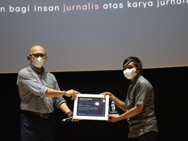Eric Sasono (Kiri) menyerahkan piagam penghargaan kepada Khaerul Anwar (Kanan) sebagai pemenang karya liputan mendalam/investigasi terbaik dalam AKJA 2021