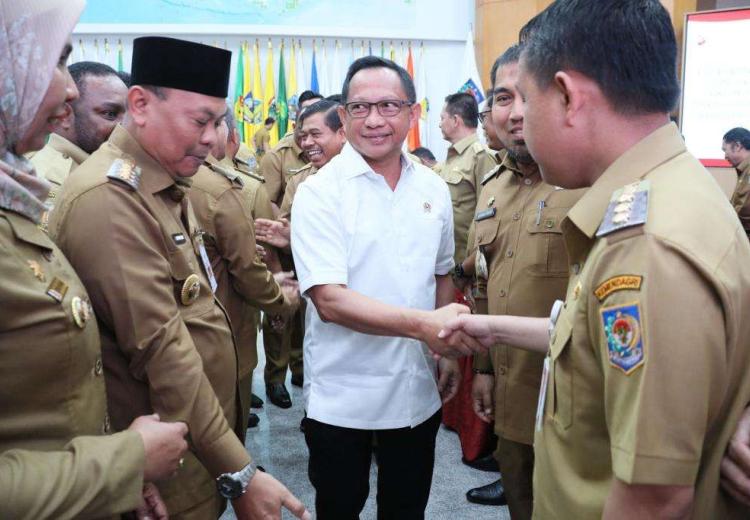 Foto Menteri Dalam Negeri Tito Karnavian Berjabat Tangan dengan Pj Bupati Aceh Besar Muhammad Iswanto SSTP MM, sembari dikelilingi sejumlah aparatur sipil negara pada Rakor Penjabat Kepala Daerah dalam Rangka Menjamin Peningkatan Kesinambungan Penyelenggaraan Pemerintahan Daerah dan Pelayanan Publik serta Implementasi Kebijakan Strategis Nasional di Daerah, di Gedung Sasana Bhakti Praja, Kantor Pusat Kemendagri, Jakarta